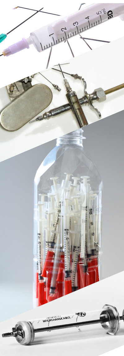 Various historical syringes on tables, in jars and individually displayed