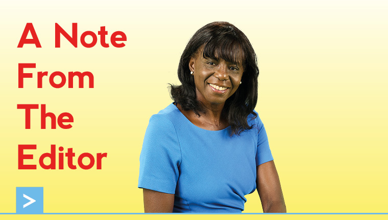 A woman with dark hair and a blue top sits beside the heading "A Note From The Editor" in red capital letters. The background is white with a blue decorative line at the bottom.